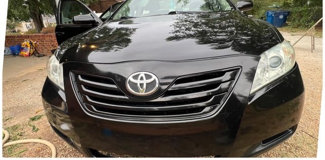 Black sedan front after washing — glossy