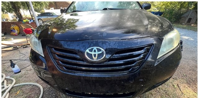 Black sedan front before washing